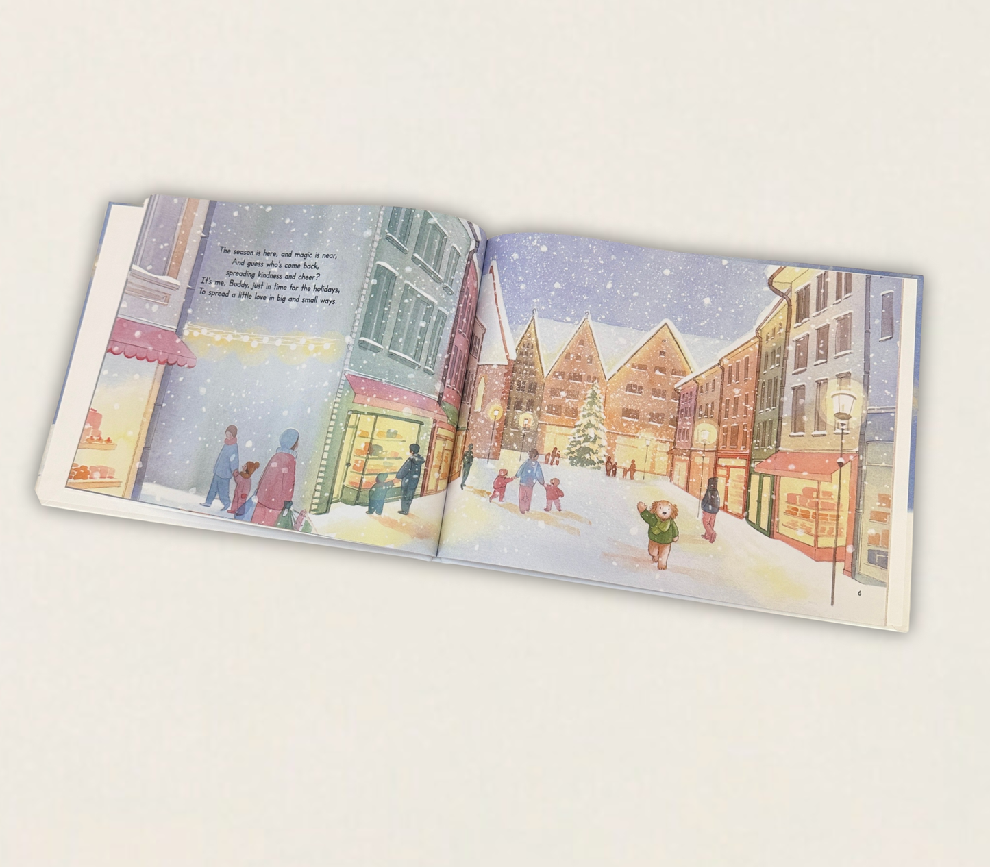 Season of Giving Buddy book open to a snowy street scene with people and buildings.
