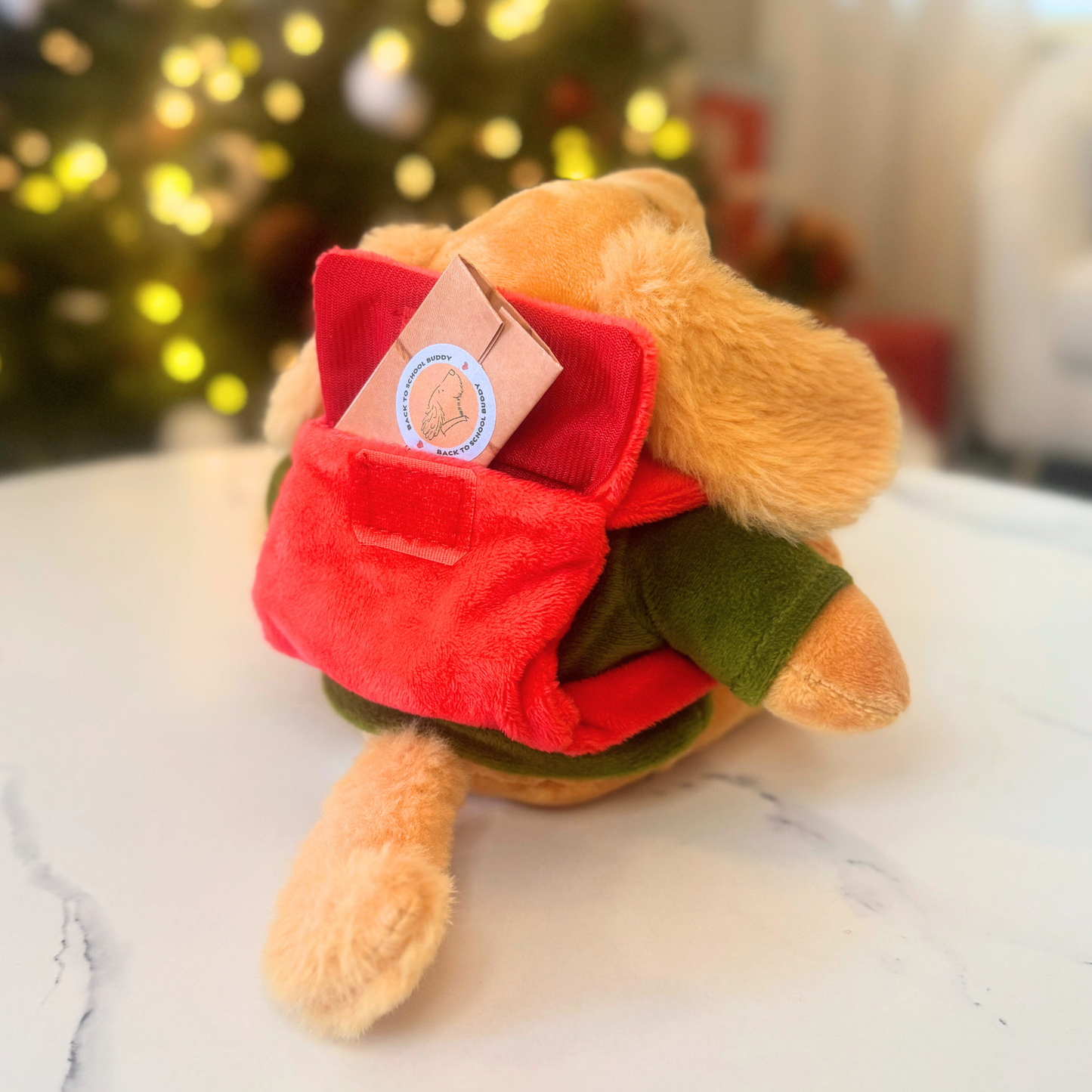 Plush Dog with red backpack revealing surprise emotional wellness note